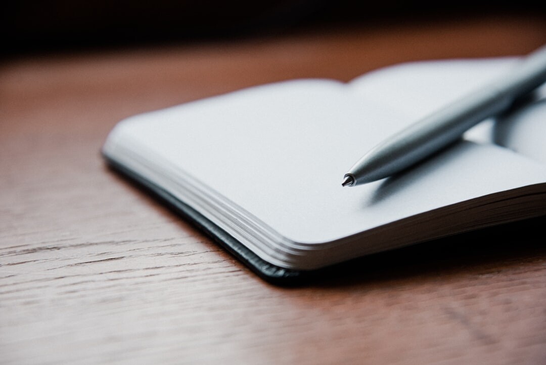 Open notebook with handwritten notes and a cup of coffee on a wooden desk